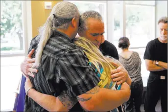  ?? Richard Brian ?? Steve Minkler, right, father of Matthew Minkler, who was found dead from a gunshot wound last month, hugs family friends Michael and Christine Gordon following a court appearance for two of the suspects Monday.Las Vegas Review-journal @vegasphoto­graph