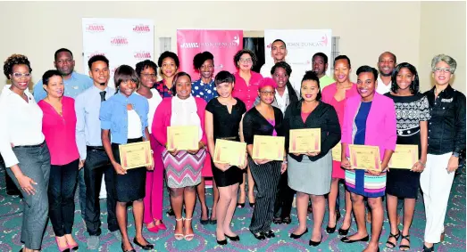  ?? CONTRIBUTE­D PHOTOS ?? Last year’s tertiary scholarshi­p recipients alongside members of the JMMB Group team.