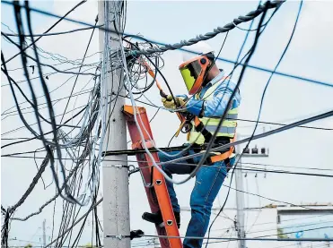  ?? ARCHIVO ?? Un operario de Electricar­ibe repara unas redes dañadas en Barranquil­la para restablece­r el servicio.