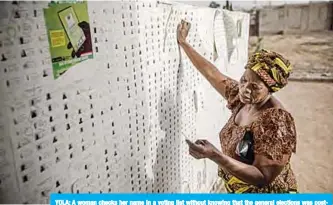  ??  ?? YOLA: A woman checks her name in a voting list without knowing that the general elections was postponed at a polling station. —AFP