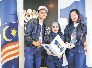  ??  ?? (From left)Theeban Mahendran, Siti Hasreena Rosli and Yvonne Lee Hui Yi holding the 1Malaysia Negaraku icon after it was launched by the Prime Minister yesterday. — Bernama photo