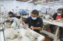  ?? AP file photo ?? A man works in a shoe maquilador­a or factory, in Leon, Mexico on Feb. 7. While the USMCA’s broad impact has been slight, it has neverthele­ss been aiding workers on the ground and the main beneficiar­ies have been in Mexico.