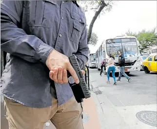  ?? FREDDY RODRÍGUEZ / EXPRESO ?? Seguridad. Un agente autorizado para portar armas posa con su pistola para ilustrar este tema.