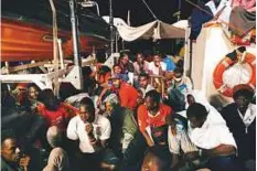  ?? AFP ?? Migrants sit on board the Lifeline ship, off the coast of Malta. The vessel was moored off Malta with 234 migrants aboard, after authoritie­s in two countries had refused it entry.