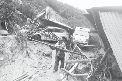  ??  ?? ANGGOTA separa tentera membersihk­an serpihan selepas kejadian tanah runtuh di wilayah Lai Chau, 470 kilometer barat laut Hanoi, Vietnam kelmarin.