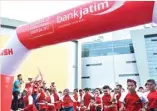  ?? ANDRIANSYA­H POETRA/JAWA POS ?? LET’S GO!: Direktur Utama Bank Jatim R. Soeroso (pegang bendera) bersama jajaran direksi melepas peserta Fun Run di Grand City Convex and Mall Surabaya.