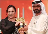  ??  ?? Award: Andria Zafirakou accepts the trophy for the Global Teacher Prize from Dubai's ruler Sheikh Mohammed.
She plans to use some of the $1 million to boost arts in schools