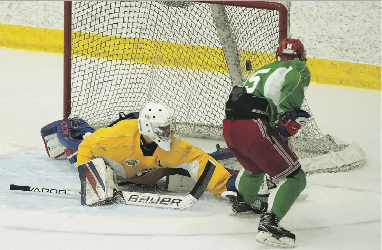  ?? LARRY WONG ?? Jesse Burchart scores on goalie Sebastion Cossa during an Oil Kings rookie game at the Downtown Community Arena, where roughly 60 players are competing for roster spots.