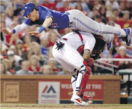  ?? JEFF ROBERSON/THE ASSOCIATED PRESS ?? Toronto Blue Jays pinch-hitter Chris Coghlan leaps over St. Louis Cardinals catcher Yadier Molina to score and take a 3-2 lead in the seventh inning on Tuesday in St. Louis. Playing in a National League park, Coghlan came in to pinch-hit for starting...