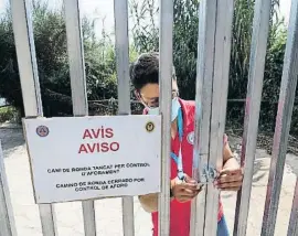  ??  ?? Un agente ciudadano cierra una puerta de acceso a la playa