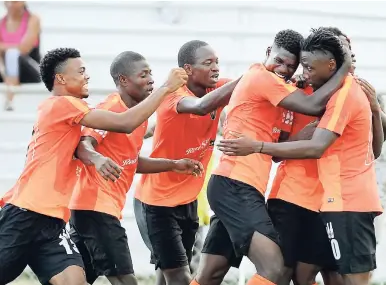  ?? RICARDO MAKYN/MULTIMEDIA PHOTO EDITOR ?? Tivoli players (from left) Romaine Breakenrid­ge, Shavar Campbell, Nicholas Smith, and Barrington Pryce mob Jermaine Johnson after he scored his second goal against Portmore United in their Red Stripe Premier League match at the Edward Seaga Complex...