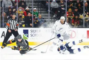  ?? The Associated Press ?? ■ Vegas Golden Knights center Mattias Janmark (26) eyes the puck after colliding withTampa Bay Lightning center Steven Stamkos (91) during the third period of an NHL game on Dec. 21 in Las Vegas.