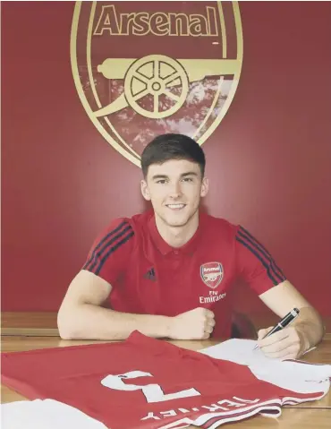 ??  ?? 0 Kieran Tierney signs his Arsenal contract before receiving a backlash of criticism from Celtic fans.