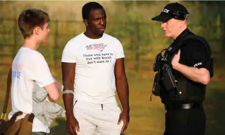  ?? Photo: Getty ?? Campaigner­s Will Dry (left) and Femi Oluwole speak to a police officer during a demonstrat­ion at Chequers.