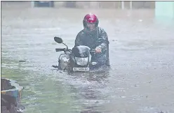  ?? HT ?? A man wades through a water-logged road after heavy downpour in Mumbai on Wednesday.