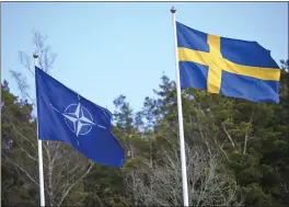  ?? FREDRIK SANDBERG — TT NEWS AGENCY VIA AP ?? The NATO flag, left, is raised next to the Swedish flag during a ceremony at the Musko navy base Stockholm on Monday. Sweden is NATO's newest member.