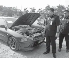  ??  ?? Haris (left) with one of the vehicles seized during the integrated operation.