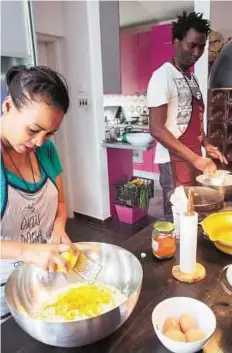  ?? AFP ?? Settling in Ethiopian Chichi Amare (left) and Nigerian David Ajobi (right) prepare breads for the “Okus Doma” project, that helps migrants and refugees to start new lives.