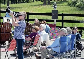  ??  ?? Doug Walker / RN-T
Louise Randall (left with camera) from Eufaula, Alabama, watches the Berry College bald eagles Saturday along with scores of B3 Branch Buddies. The Facebook group has a couple of meetings at the nest site near the Cage Center each...