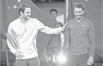  ?? AGENCE FRANCE PRESSE FILE PHOTO ?? Winner Roger Federer of Switzerlan­d (L) and second-placer Rafael Nadal of Spain react as they hold their trophies after the men's singles final match at the Shanghai Masters tennis tournament in Shanghai.