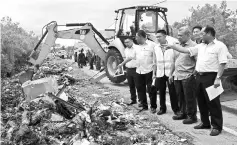  ??  ?? Jumaini (right ) points to the heap of rubbish at Jalan Akses FAC Kuching. With him are officers from Trienekens, JKR and DBKU. — Photo by Jeffery Mostapa.