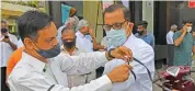  ?? (AFP) ?? People tie black bands on their arms as they gather outside the church for a memorial mass for the priest, in Mumbai on Tuesday