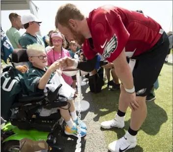  ?? MATT ROURKE - ASSOCIATED PRESS ?? Eagles quarterbac­k Carson Wentz bumps fists with 11-year-old Giovanni Hamilton, who is attending the practice as part of a wish granted by Bianca’s Kids at the NFL football team’s training camp in Philadelph­ia, Friday.