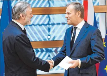  ?? FOTO: AFP ?? Der britische EU-Botschafte­r Tim Barrow überreicht EU-Ratspräsid­ent Donald Tusk (re.) in Brüssel das Schreiben von Premiermin­isterin May zum EU-Austritt von Großbritan­nien.