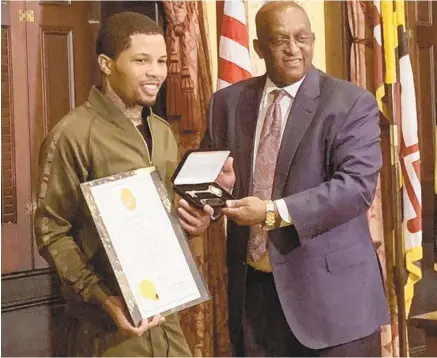  ?? GIANA HAN/BALTIMORE SUN ?? World champion boxer Gervonta Davis is presented with a key to the city by Baltimore Mayor Bernard C. “Jack” Young on Wednesday.