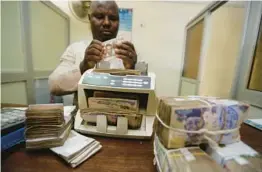  ?? SUNDAY ALAMBA/AP 2015 ?? Nigerian currency is counted in Lagos. Nigeria’s push to replace the local currency notes with newly designed ones is creating an economic crisis, experts say.