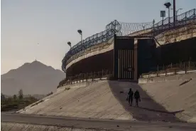  ?? Photograph: Paul Ratje/AFP via Getty Images ?? Migrants walk along the border wall in El Paso, Texas, on 19 May 2022.