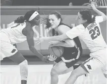  ?? MICHAELWOO­DS/AP ?? UConn freshman guard Nika Muehl tries to get past Arkansas defenders Marquesha Davis, left, and Amber Ramirez on Jan. 28 in Fayettevil­le, Arkansas.