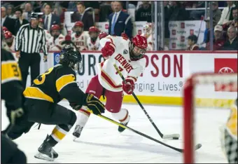  ?? PHOTOS BY DANIEL BRENNER — SPECIAL TO THE DENVER POST ?? Forward Aidan Thompson of the Denver Pioneers shoots in the second period of the game against the Colorado College Tigers Friday at Magness Arena.