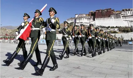  ?? / AP PHOTO ?? CRACKDOWN. In this file photo, Chinese paramilita­ry police march during a flag raising ceremony near the Potala Palace in Lhasa in western China’s Tibet Autonomous Region.