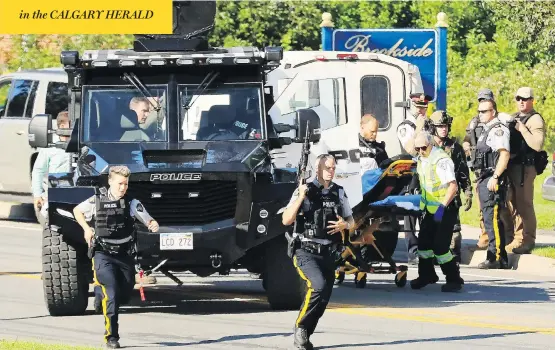  ?? KEITH MINCHIN / THE CANADIAN PRESS ?? Local police and RCMP officers respond to the scene in Fredericto­n, N.B., Friday, where two Fredericto­n officers were killed, along with two civilians. Seven others were injured.