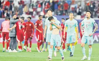  ?? — AFP photo ?? China’s players (right) react after the match.