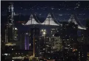  ?? MARCIO JOSE SANCHEZ — AP PHOTO ?? The San Francisco Oakland Bay Bridge is illuminate­d over downtown buildings at dawn, Dec. 22, 2016, in San Francisco. The famous Bay Bridge lights may soon go dark, unless Ben Davis, founder of Illuminate, can persuade enough millionair­es to donate $10million to keep, expand and upgrade the display.