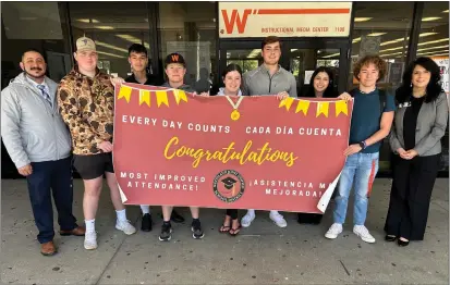  ?? COURTESY ?? Woodland High School Principal Gerald Salcido (left), students and Woodland School District Superinten­dent Elodia Ortega Lampkin (right) with the attendance banner.