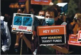  ?? PHOTOS BY KARL MONDON — STAFF PHOTOGRAPH­ER ?? A protester carries a cardboard Muni bus model during a march to the Metropolit­an Transporta­tion Commission headquarte­rs on Thursday in San Francisco. Protesters are upset about the agency’s delay in spending pandemic relief funds to restore full transit service.