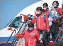  ?? LONG LEI / XINHUA ?? Medical profession­als from Liaoning province sent to support Wuhan’s hospitals in the fight against COVID-19 return to Shenyang Taoxian Internatio­nal Airport on March 28.