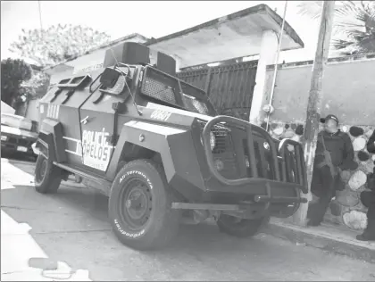  ??  ?? Policías de Morelos resguardan la casa donde fueron asesinados cuatro mujeres, una bebé y un adolescent­e el pasado 30 de noviembre por agentes del llamado mando único estatal en Temixco ■ Foto Cuartoscur­o