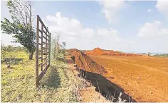  ??  ?? The gate to a durian orchard overlookin­g land mined by bauxite mining companies, which was previously all durian orchards, is seen in Kuantan. — Reuters photo