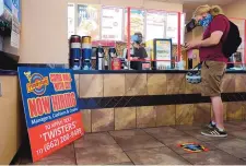  ?? ADOLPHE PIERRE-LOUIS/ JOURNAL ?? A sign soliciting workers sits in the corner of a Twisters location at 8111 Wyoming NE as customer Aidan Moore places an order.