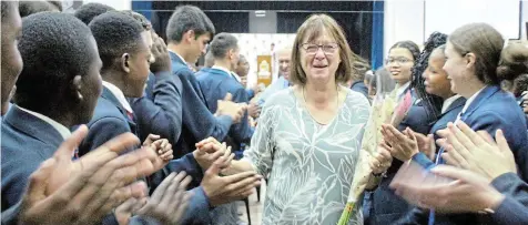  ?? Picture: SUE MACLENNAN ?? HEARTFELT TRIBUTE: An emotional Chix Pearson leaves her final assembly at Port Alfred High School through a tunnel of cheering, clapping pupils. The much loved staff member is retiring after 19 years of service to the school.