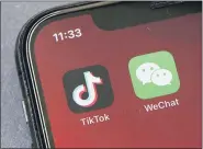  ?? ASSOCIATED PRESS FILE PHOTO ?? Icons for the smartphone apps TikTok and WeChat are seen on a smartphone screen in Beijing. The Commerce Department said President Trump’s proposed ban of the apps WeChat and TikTok will go into effect Sunday to “safeguard the national security of the United States.”