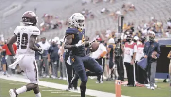  ?? ASSOCIATED PRESS ?? WEST VIRGINIA RUNNING BACK LEDDIE BROWN (4) rushes in for a touchdown against Eastern Kentucky during a game on Saturday in Morgantown, W. Va.