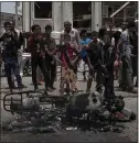  ??  ?? Civilians check out one of the three motorcycle­s used by suicide bombers against the Aden police station.