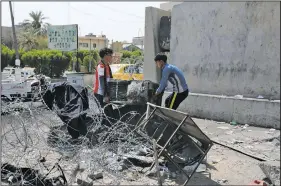  ?? AP/NABIL AL-JURANI ?? Workers remove damaged furniture Saturday from a burned government building in Basra, Iraq.