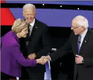  ?? AP PHOTO/PATRICK SEMANSKY ?? Democratic presidenti­al candidates Sen. Elizabeth Warren, D-Mass., left, and Sen. Bernie Sanders, I-Vt., right greet each other as former Vice President Joe Biden, watches Tuesday before a Democratic presidenti­al primary debate hosted by CNN and the Des Moines Register in Des Moines, Iowa.