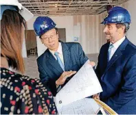  ??  ?? Wei Chen, dean of the College of Mathematic­s and Science, left, and President Don Betz talk about the plans for the new STEM building on the University of Central Oklahoma campus during a recent tour.